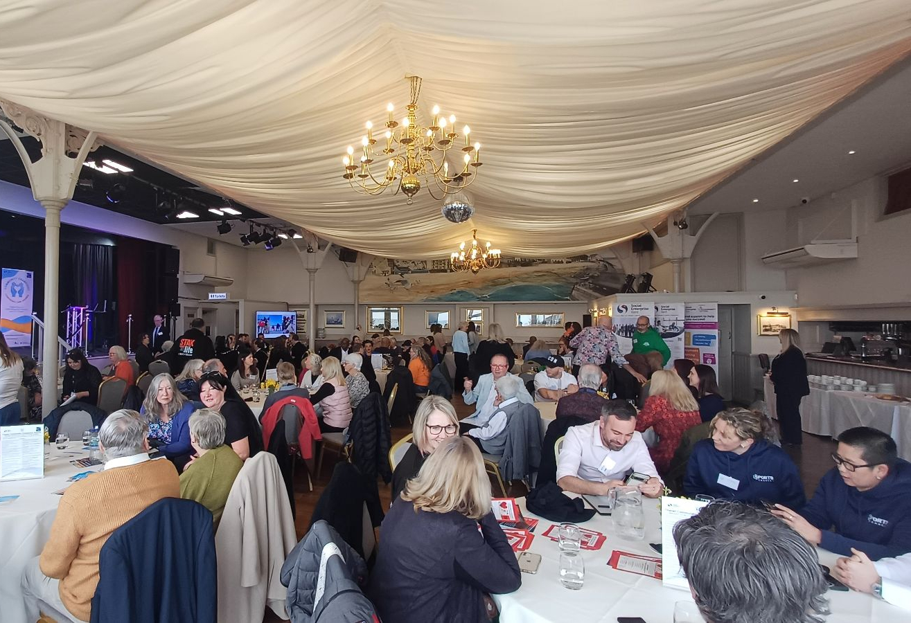 People sitting at tables inside the Pavilion in Broadstairs. The room is decorated for an awards ceremony.